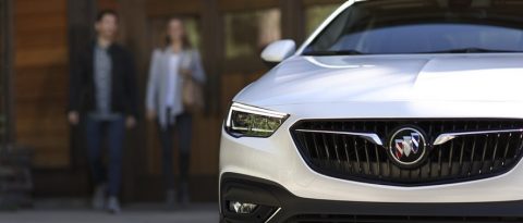 Couple walking toward Buick SUV parked in foreground