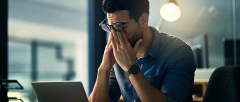 hombre estresado frente a su computadora portátil