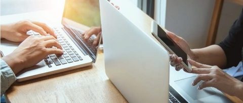 Two people working on laptops