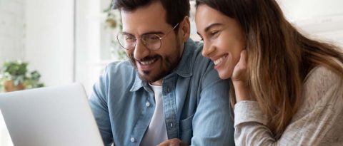 Smiling couple working on budget together