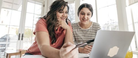 Mother and teen reviewing finances on a laptop