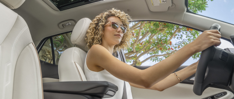 Smiling woman in sunglasses cruising to work.